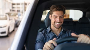 Buying an EV man smiling while driving car